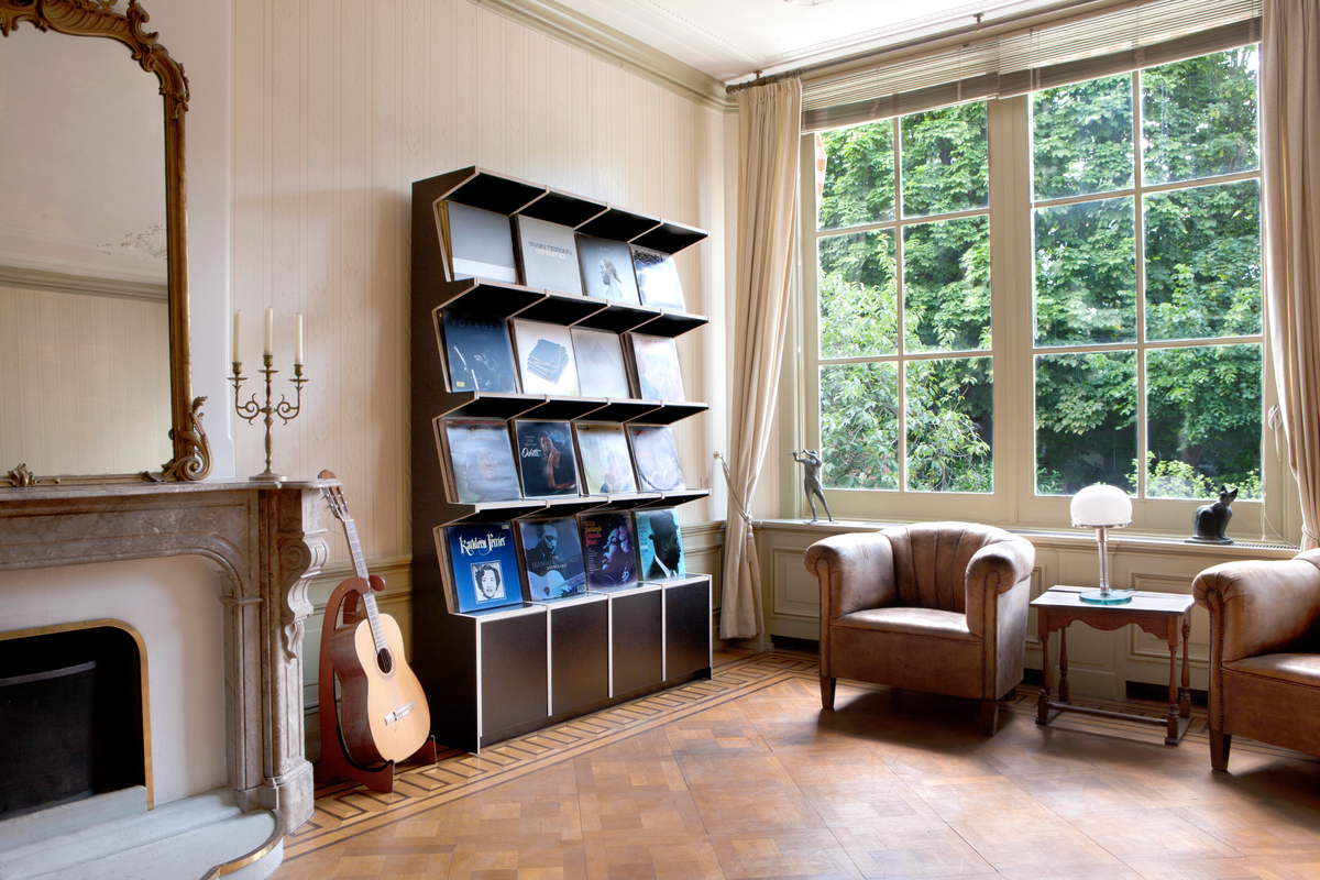 Coverfront record cabinet in black birch plywood, four wide and four high, in a bright classic living room with tall windows