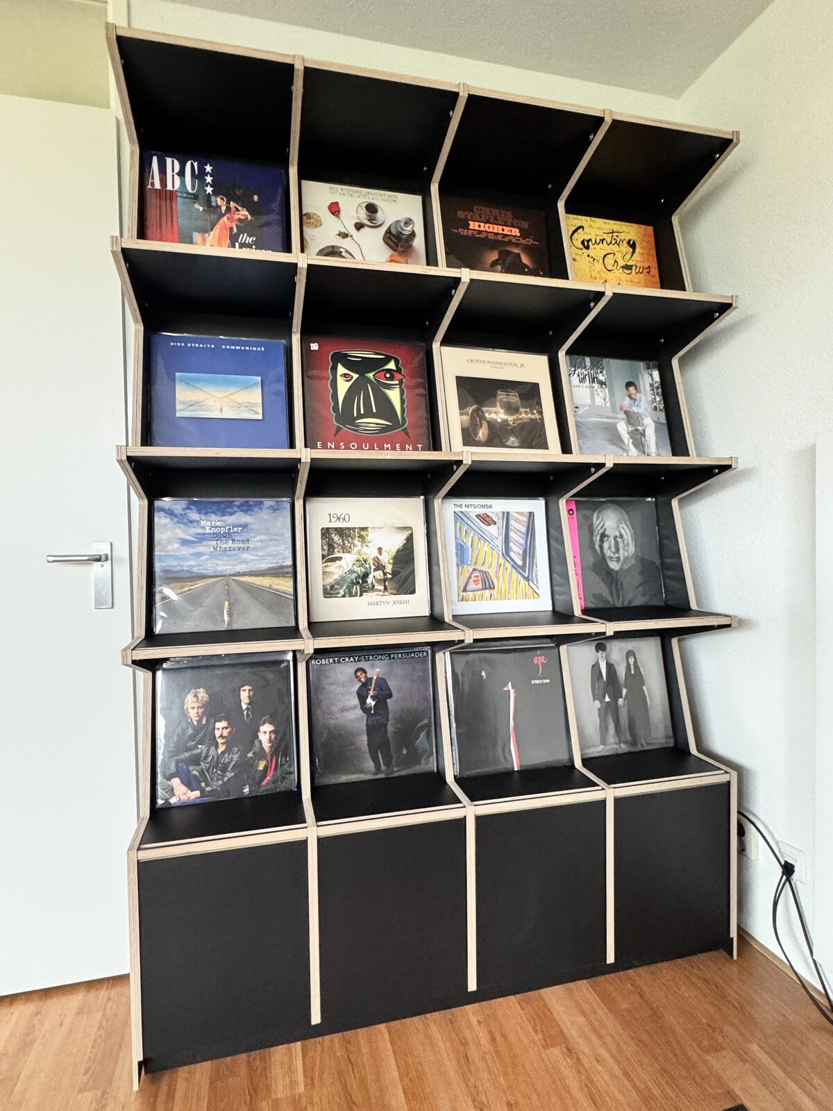 Ophon Coverfront record cabinet in birch plywood, black, four columns, four compartments high, with records standing cover-forward