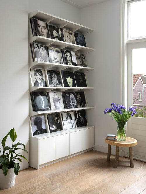 Coverfront record cabinet, spray-painted white, four wide and five high, against a white wall